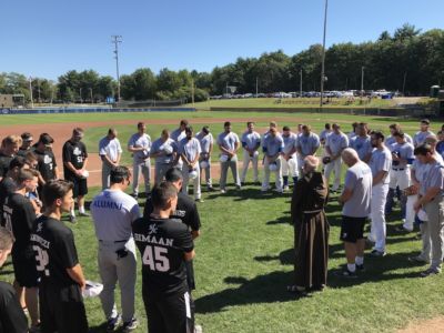 Father John Tokaz leads alumni baseball players in prayer.