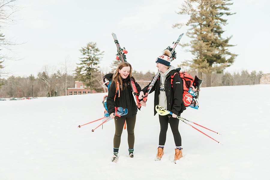female skiers walk across campus