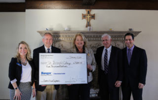 Members of Bangor Savings and SJC hold up the check for $5,000
