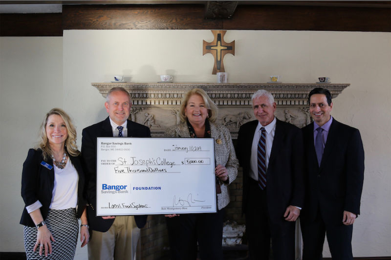 Members of Bangor Savings and SJC hold up the check for $5,000