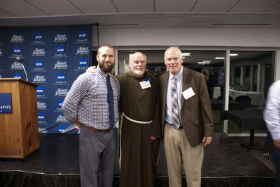 Hall of Fame inductee Derek McIntosh, class of '05, poses with Father John Tokaz and Coach Will Sanborn