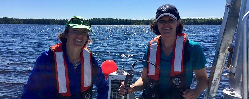 Emily Lesher and Brie Holme calibrating sensors on Sebago Lake