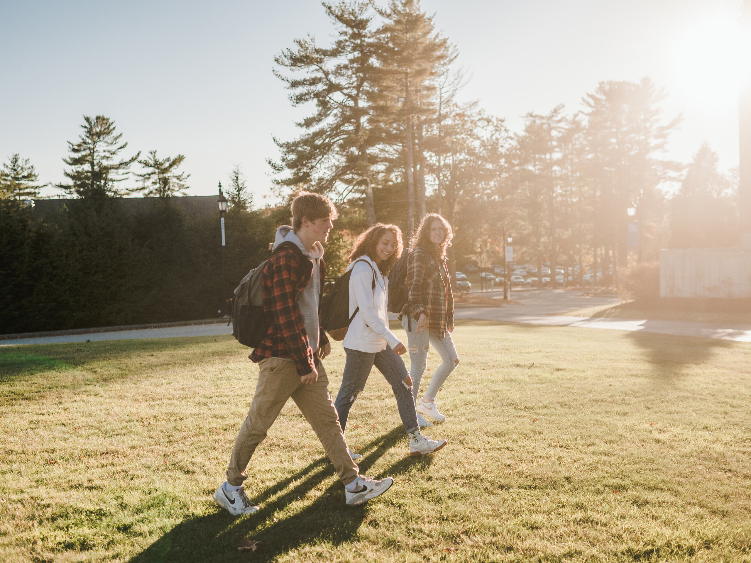 A group of students walk across the campus of Saint Joseph's College of Maine.
