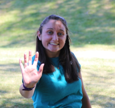 MaryClaire holds her hand out in a high-five, which is the logo for SJC Peer Mentors
