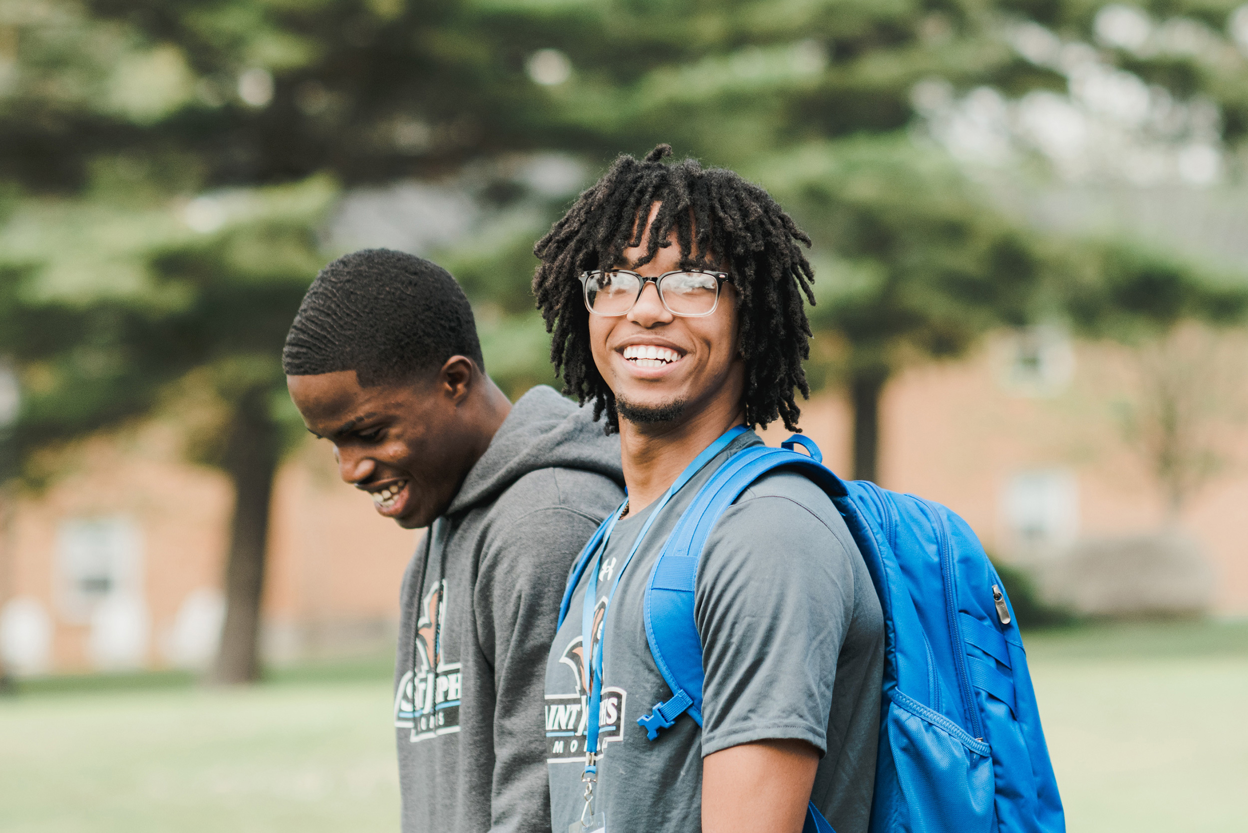 Two male students walk across campus during new student orientation