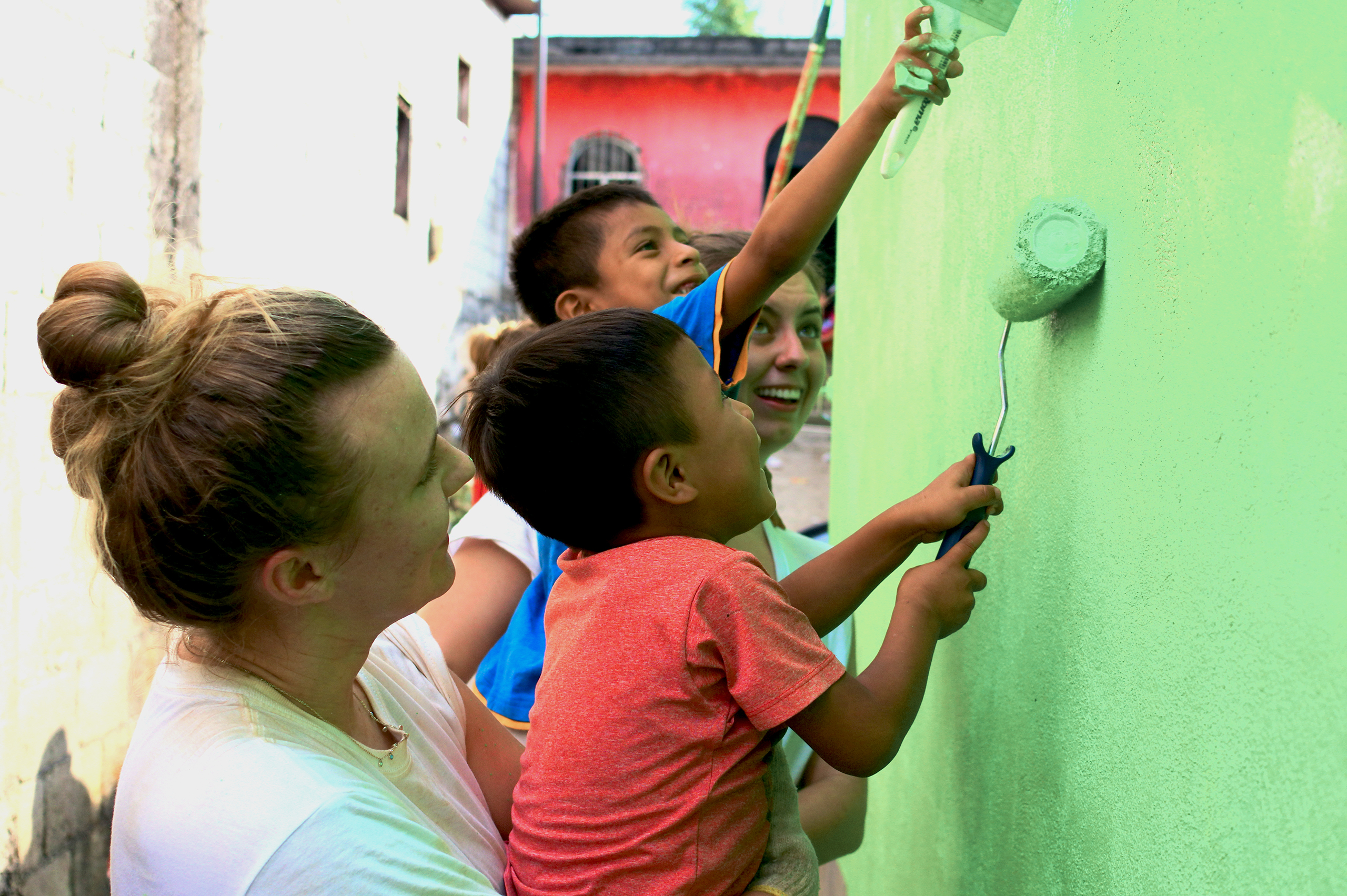 SJC student paints a wall in a Guatemalan home