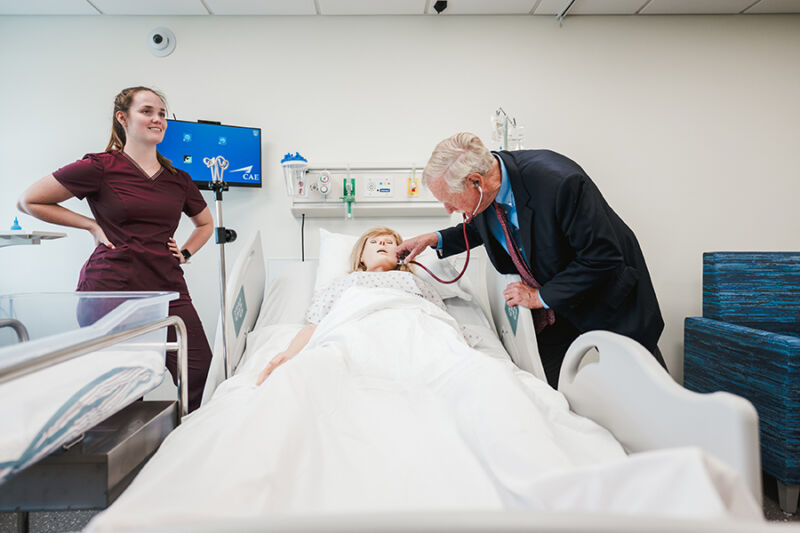 Senator Angus King listens to the heart beat of a simulation mannikin at the Center of Nursing Innovation at Saint Joseph's College of Maine