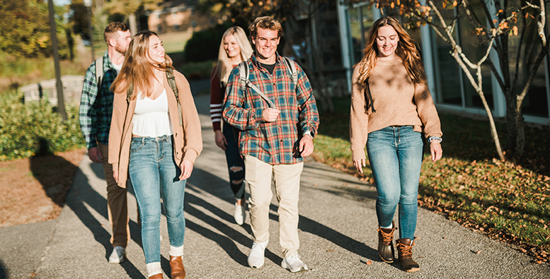 A group of students walking across campus in the fall