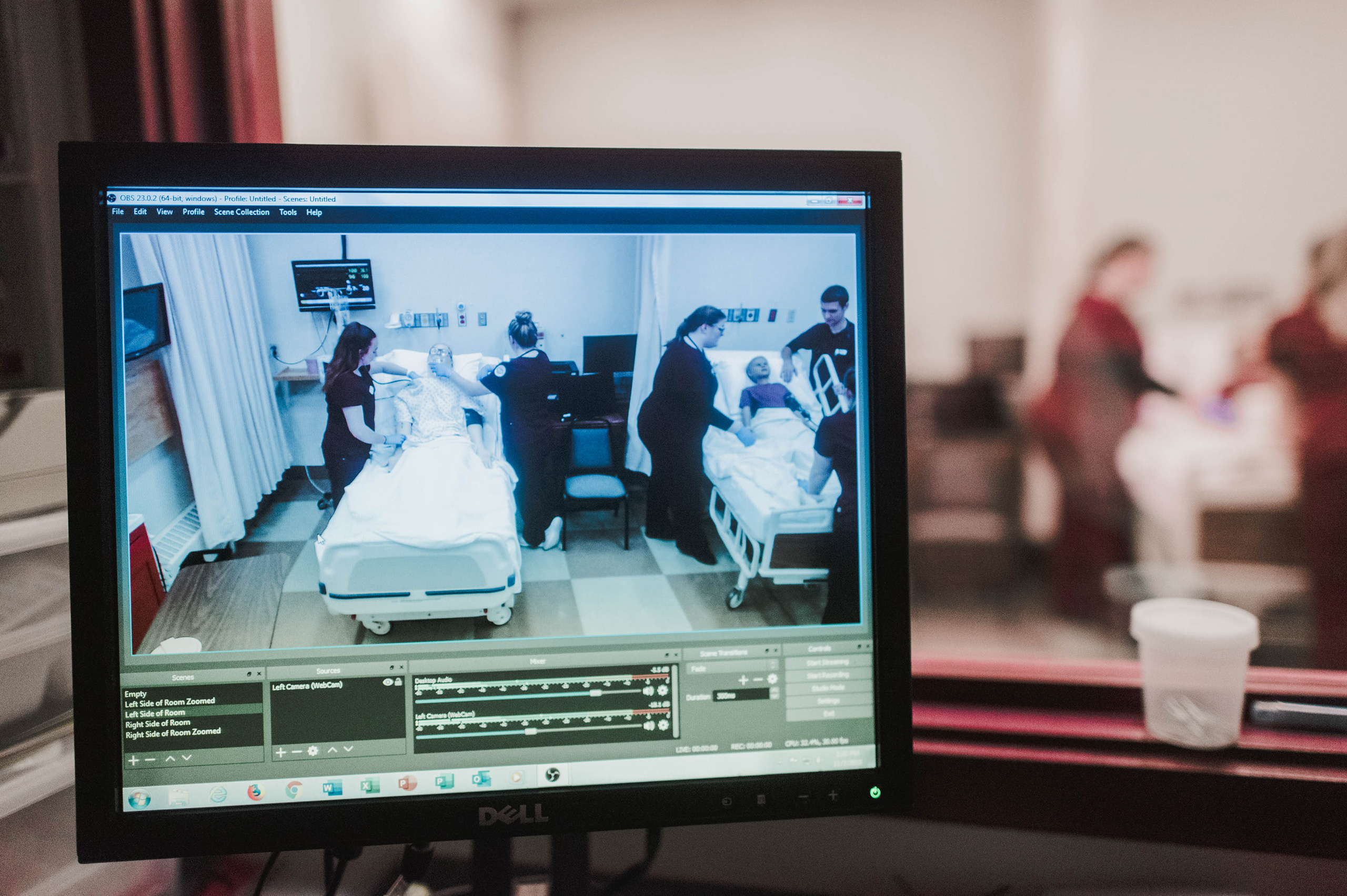 nursing professors instruct students in simulation lab