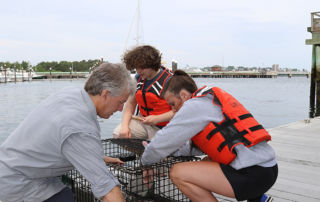 Professor Steve Jury, students Bailey Gryskwicz and David Glass work on a lobster trap for research