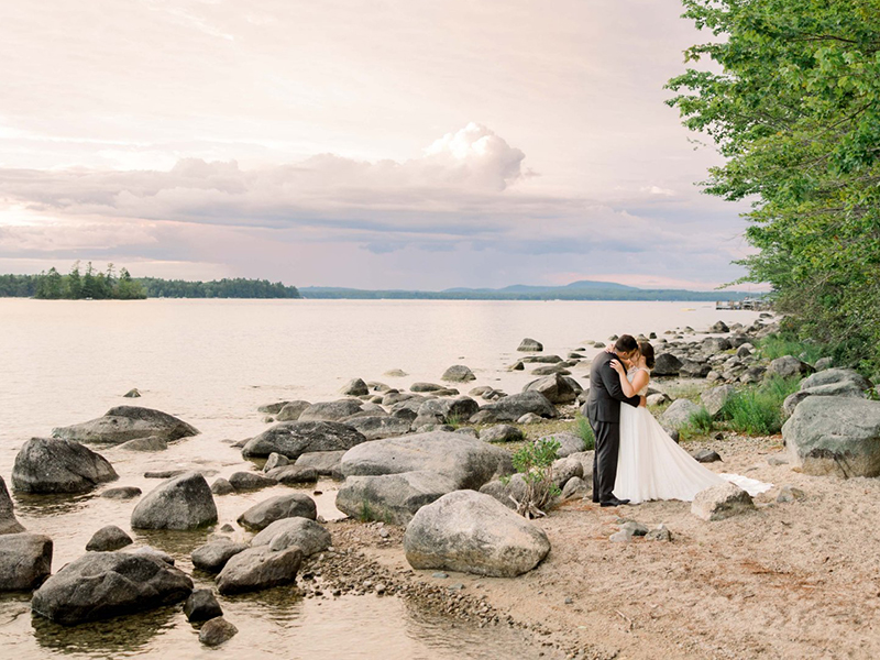 Bride and groom poise at the lakefront